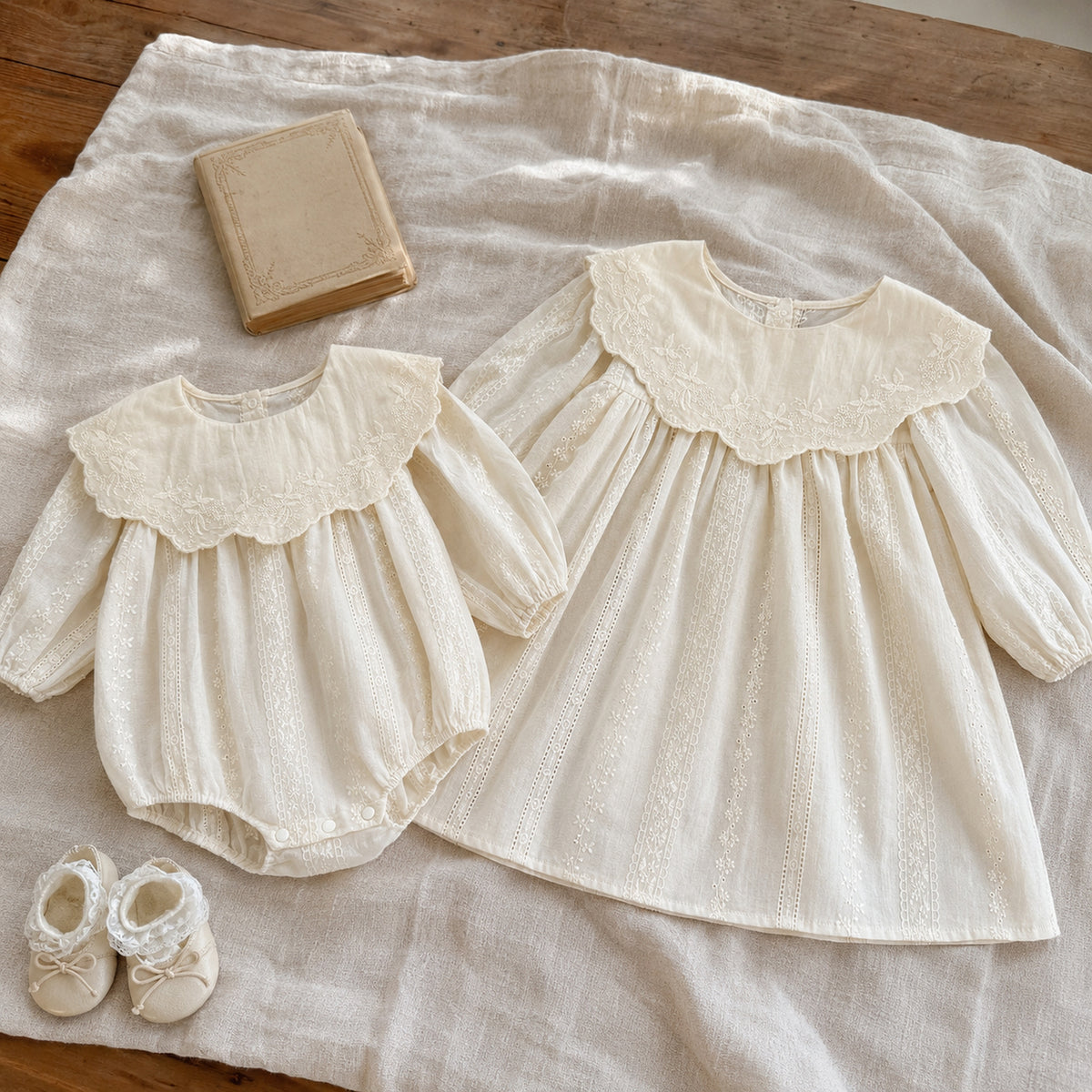 Ivory baby romper and matching girls dress displayed together on natural linen