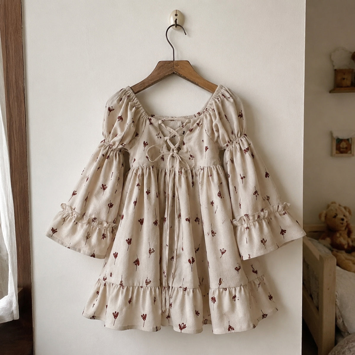 Beige floral long puff sleeve girls dress hanging naturally in a sunlit bedroom