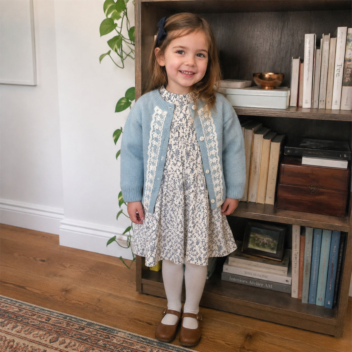Girls powder blue lace cardigan and ivory blue floral long sleeve dress - worn indoor lifestyle view