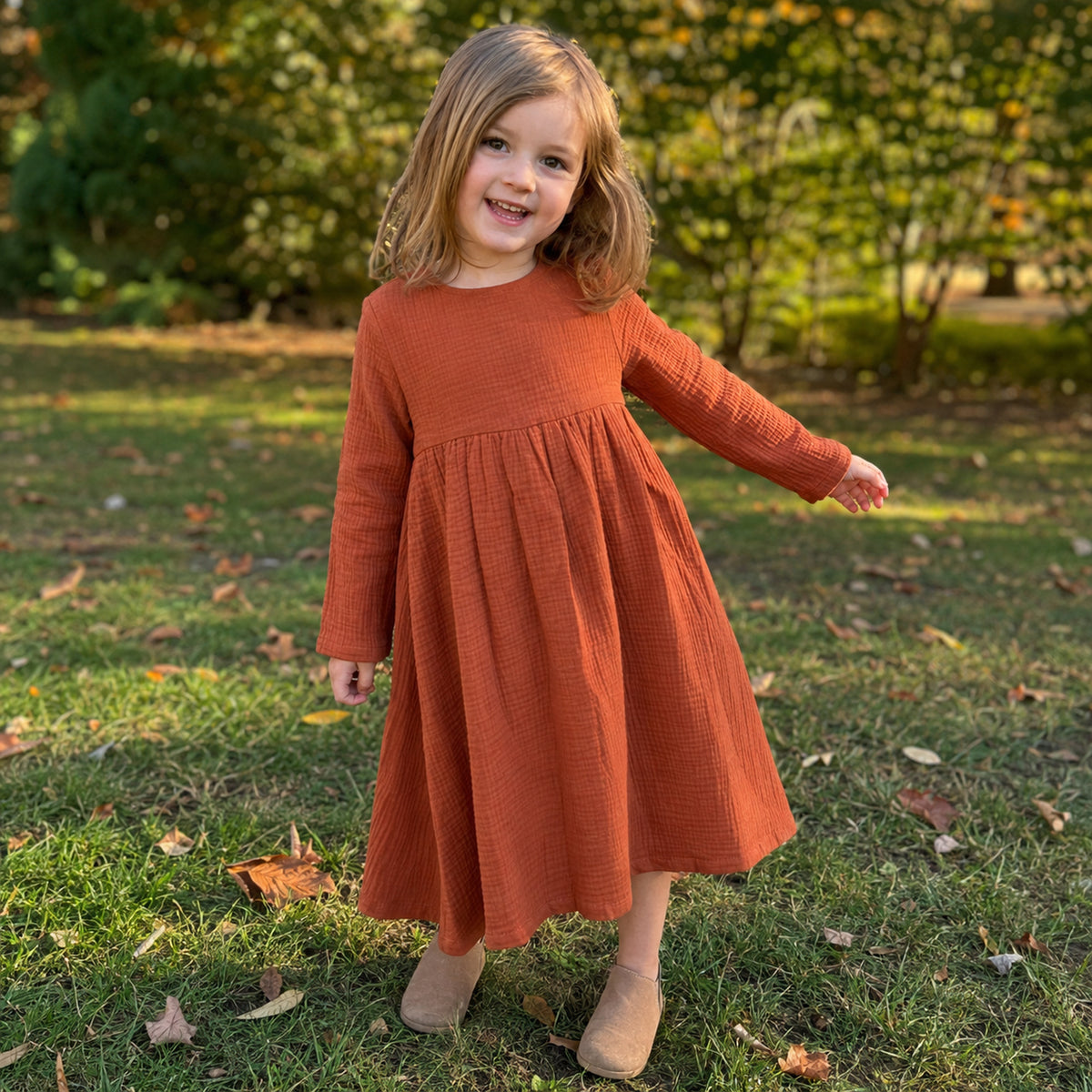 Rust red cotton gauze girls dress worn outdoors