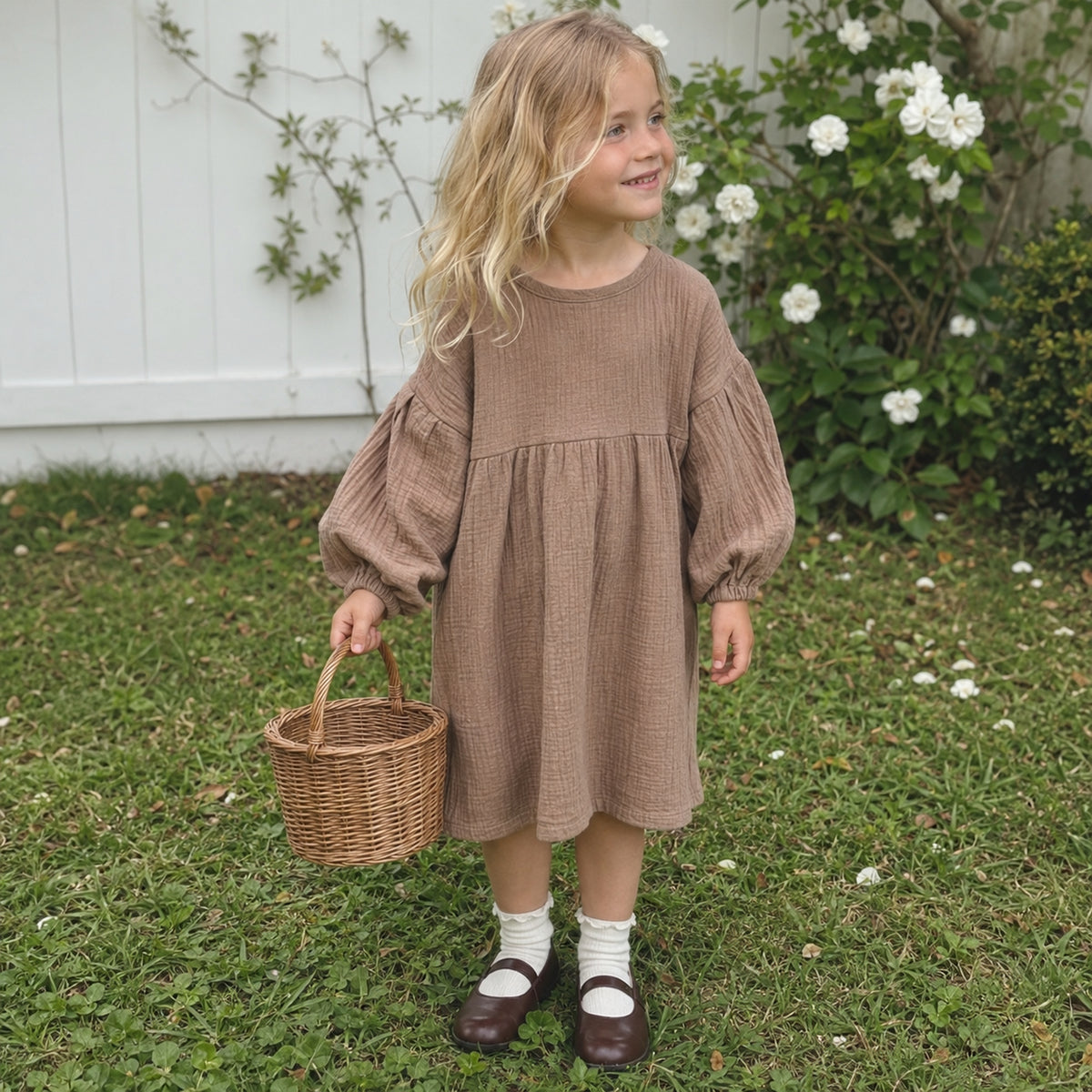 Brown toddler muslin dress worn in garden