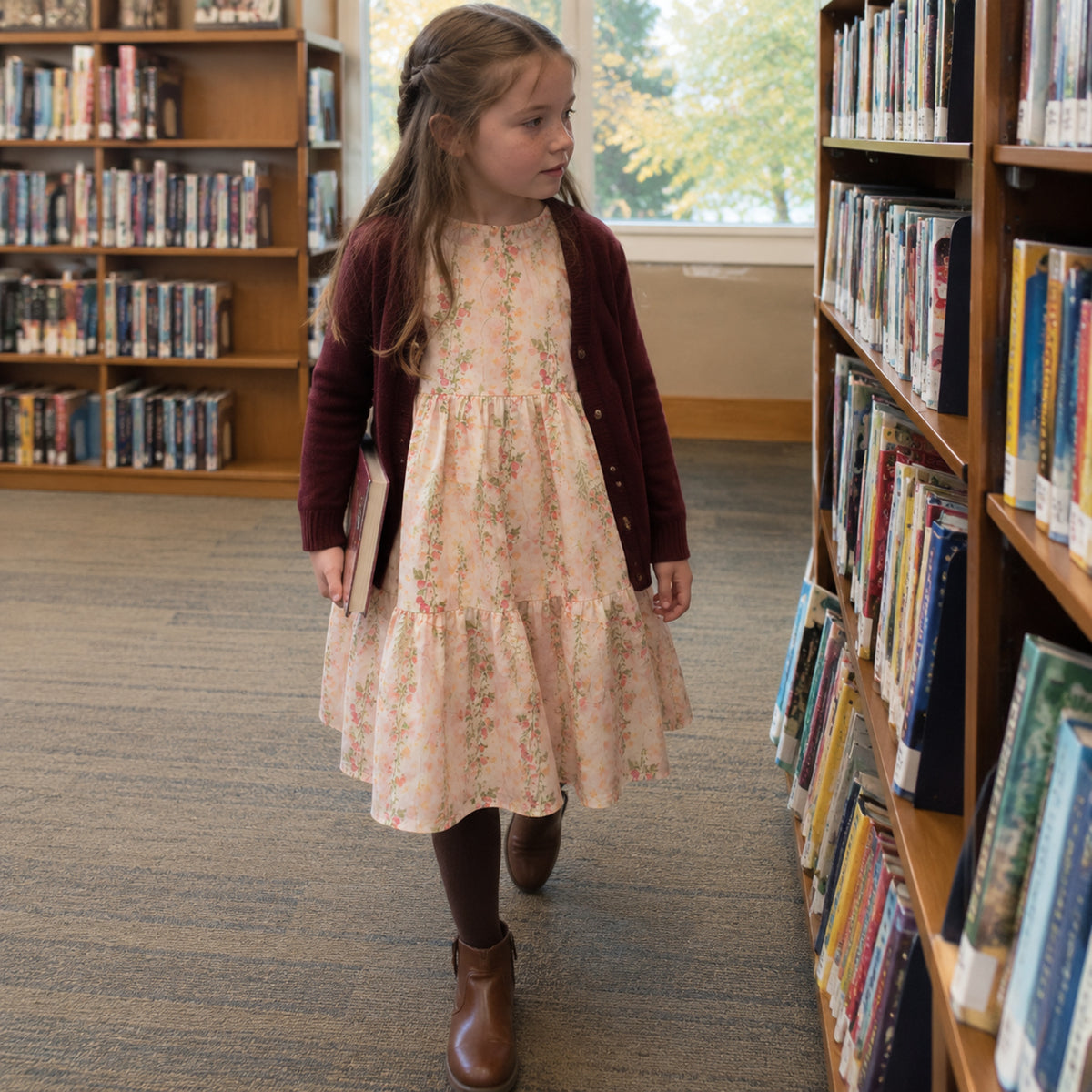 Seven-year-old wearing pink floral midi dress with burgundy cardigan and cocoa tights