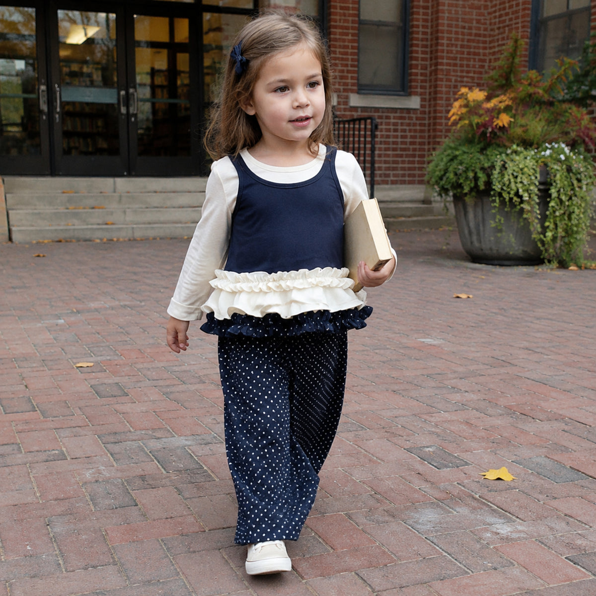 Girl wearing navy and cream two-piece fall outfit outside a school library