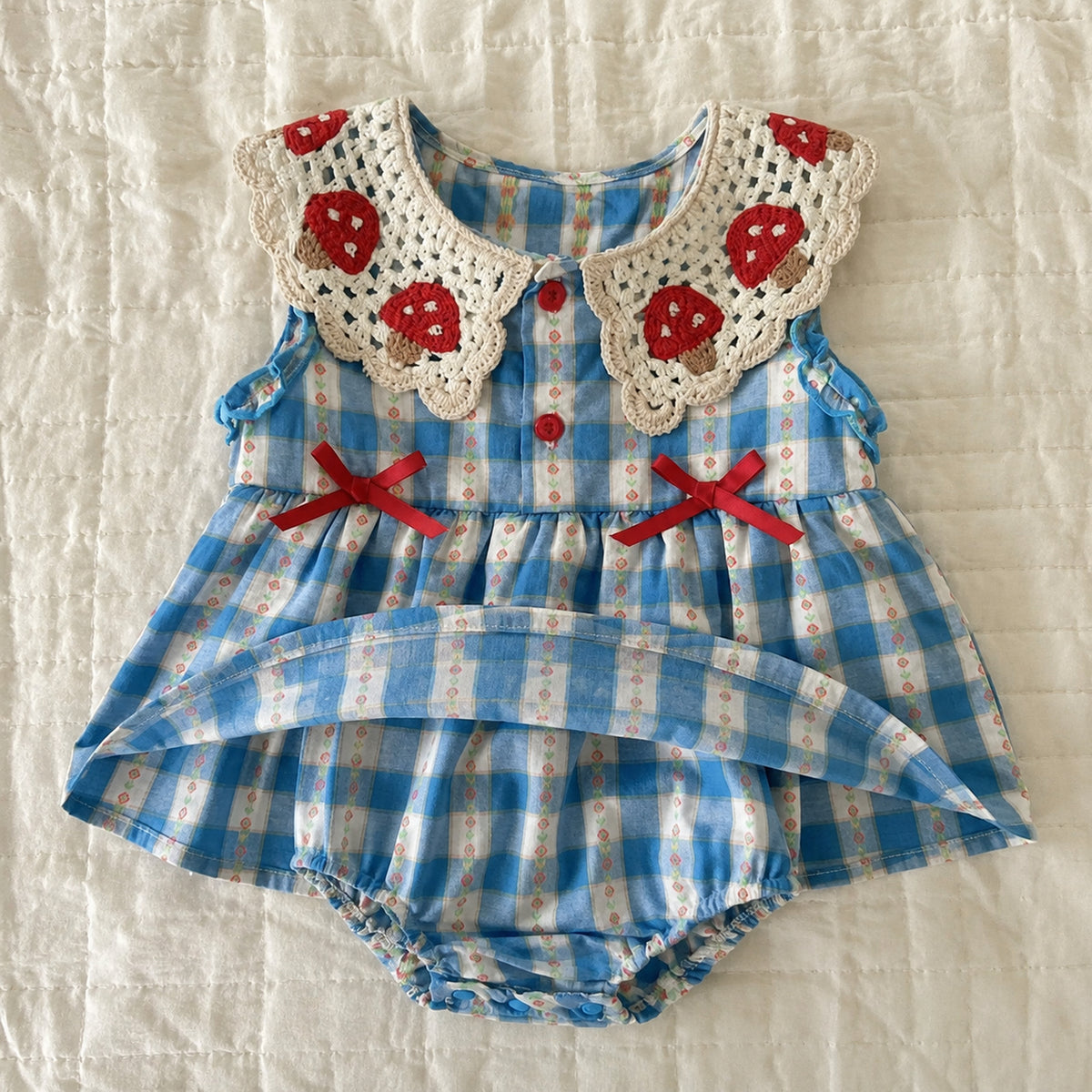 Baby blue gingham romper dress with crochet strawberry collar and red bows - flat lay full product view