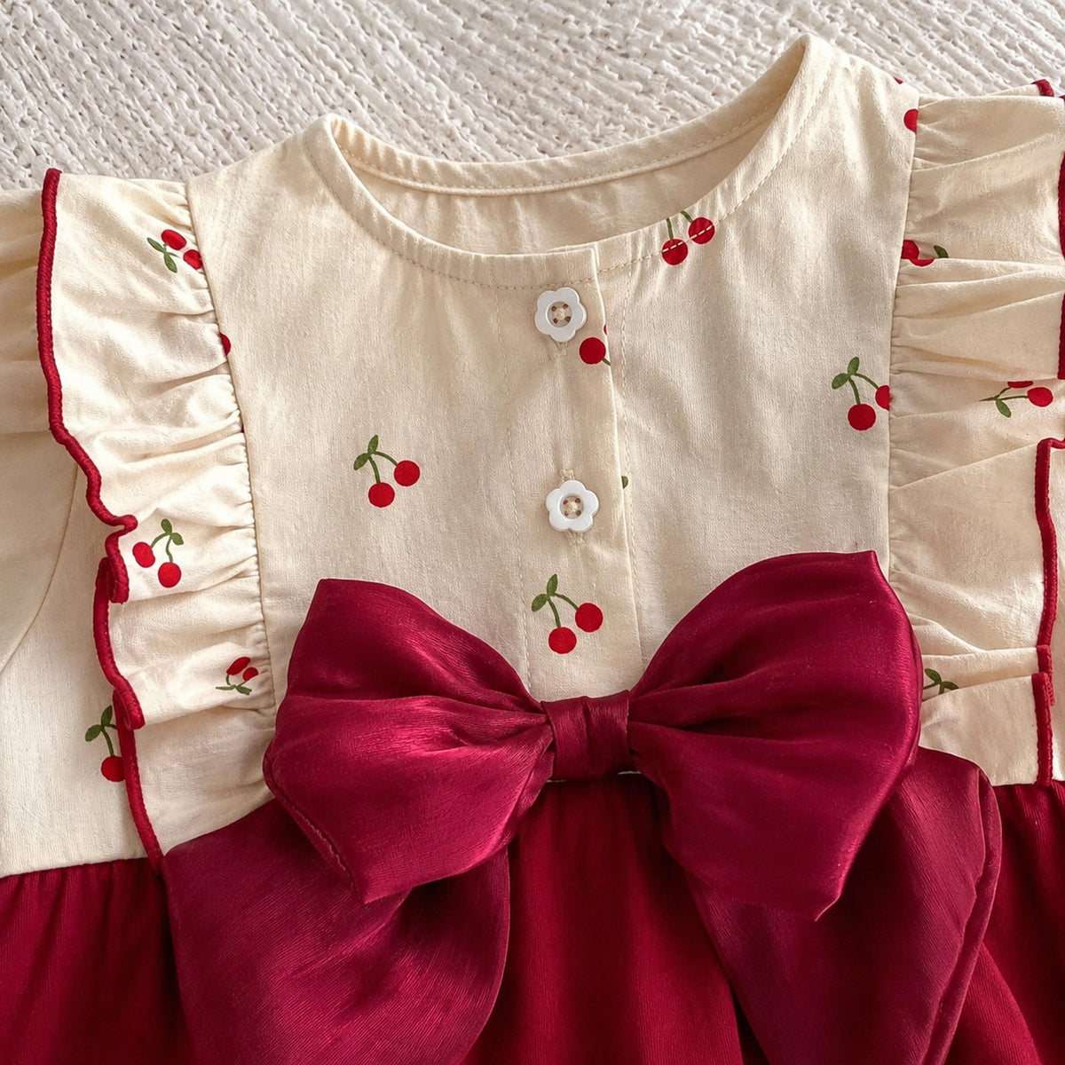 Baby burgundy velvet romper with cherry print long sleeves and large bow - collar and bodice detail
