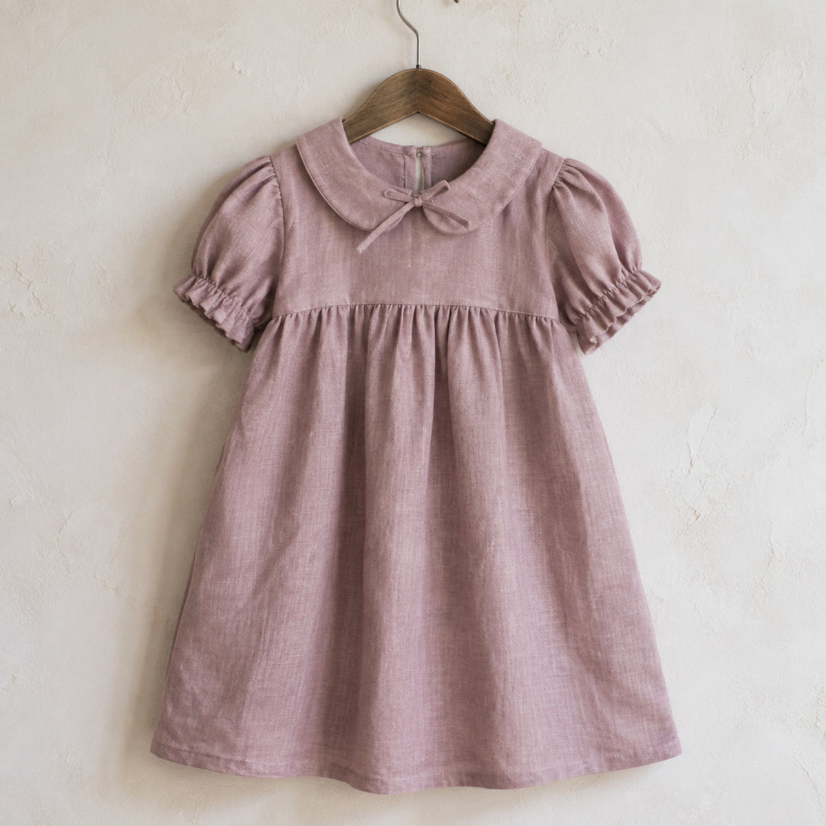 Dusty mauve Peter Pan collar linen-blend girls dress on a wooden hanger