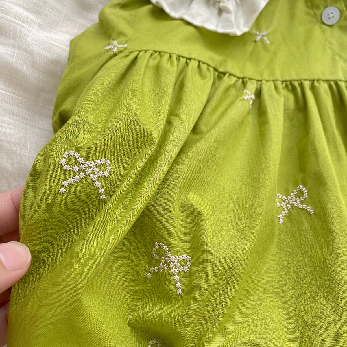 Tiny ivory bow embroidery on green cotton fabric