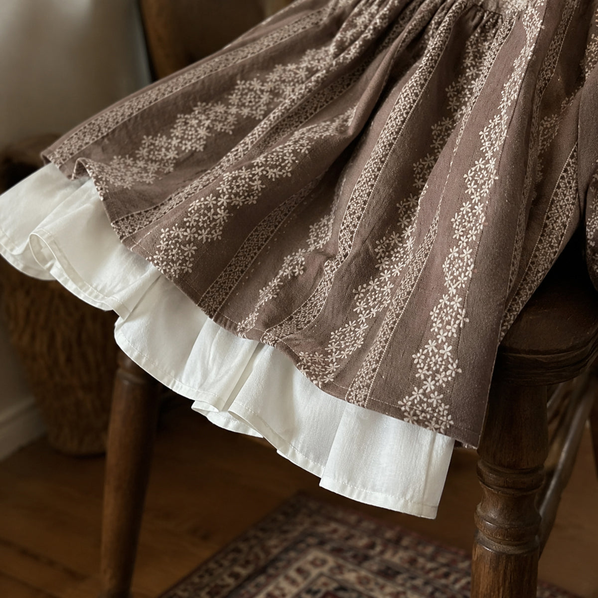 Close-up of the taupe printed skirt and wide cream underlayer ruffle hem