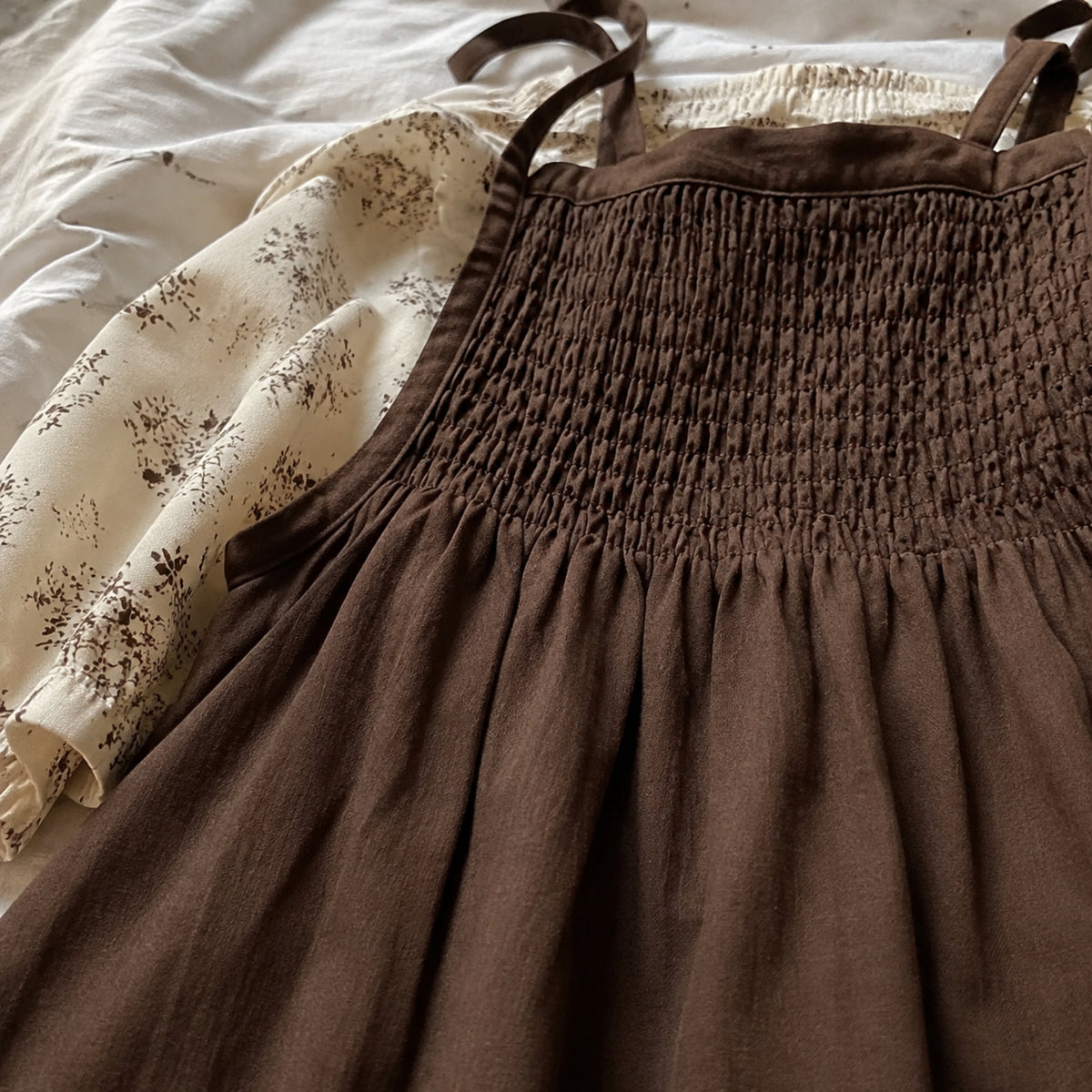 Close-up of the deep coffee smocked bodice and gathered waist