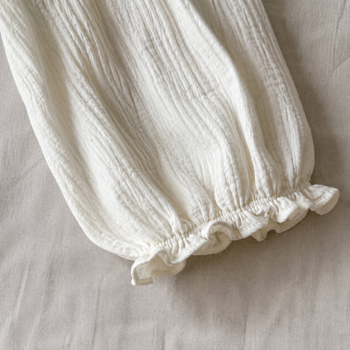 Close-up of the ivory blouse lantern sleeve and gathered ruffle cuff