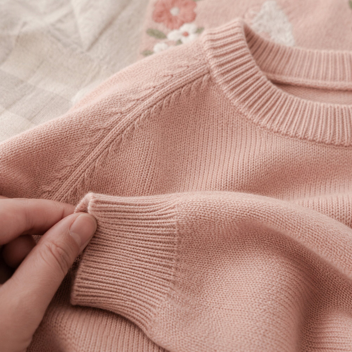 Close-up of the ribbed neckline, raglan seam and cuff knit texture