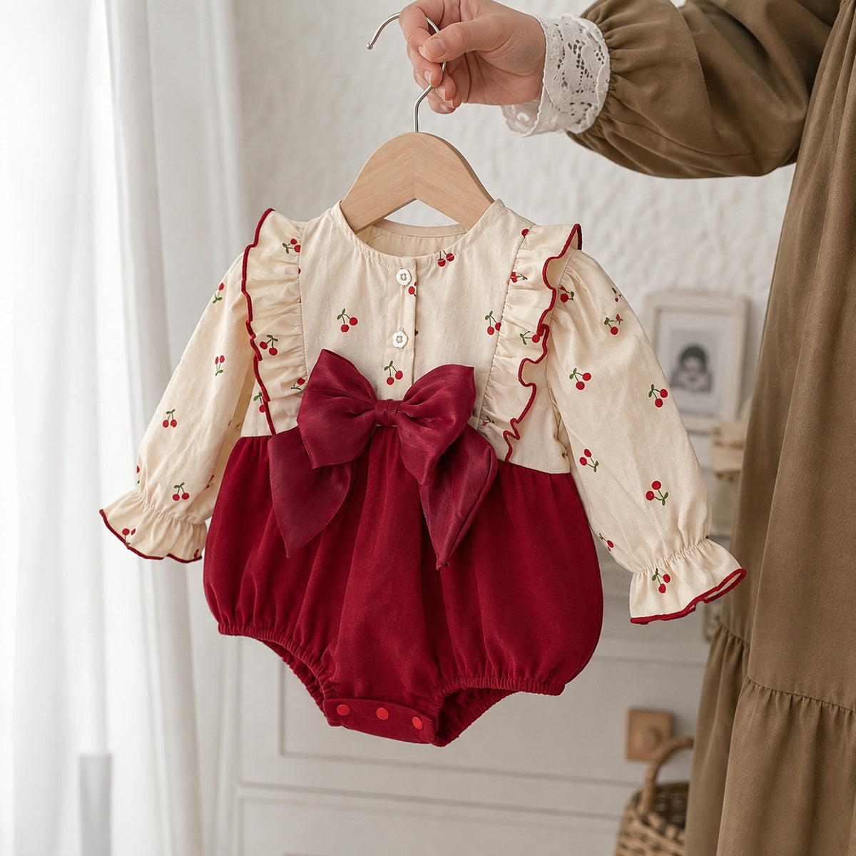 Baby burgundy velvet romper with cherry print long sleeves and large bow - three quarter product detail