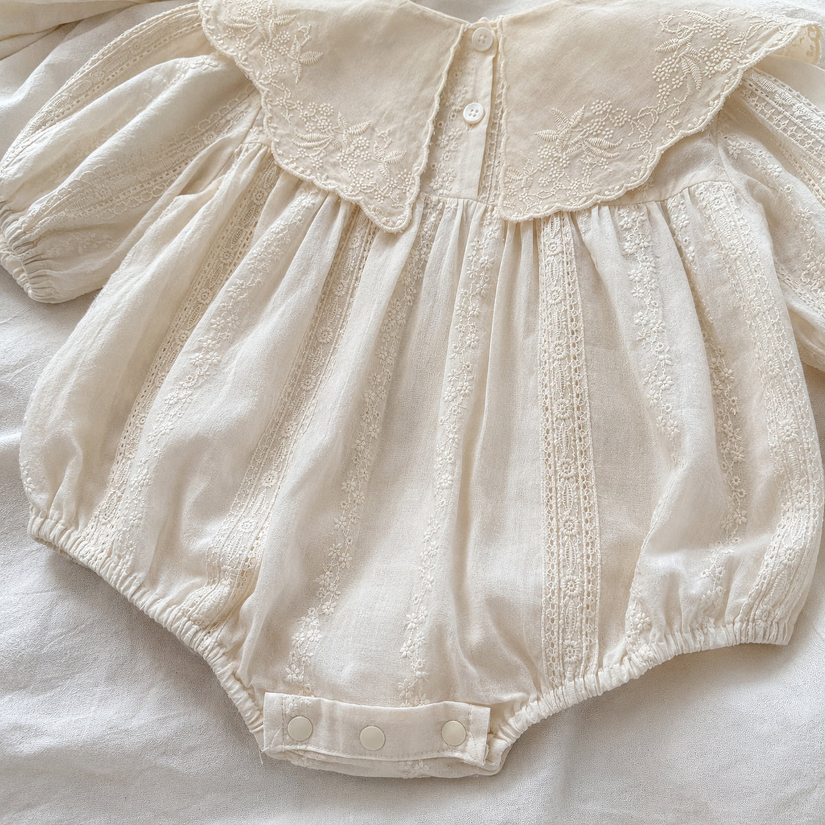 Close-up of romper snap closure and elastic leg openings