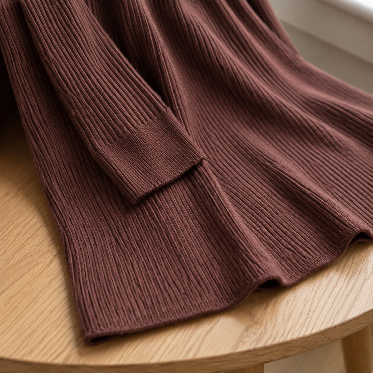 Close-up of chocolate rib knit sleeve cuff and clean midi skirt hem