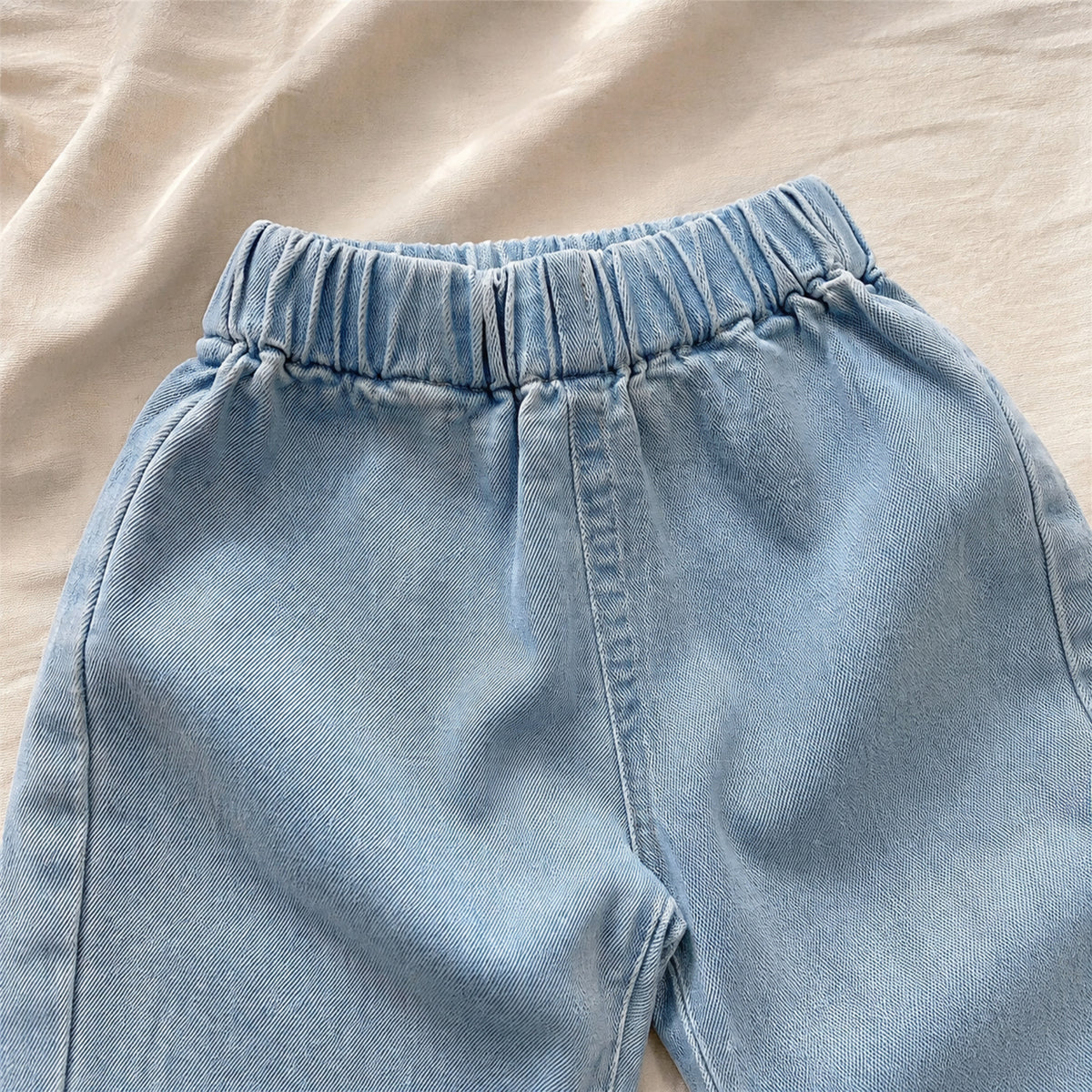 Close-up of the light denim pants elastic waistband and soft twill texture