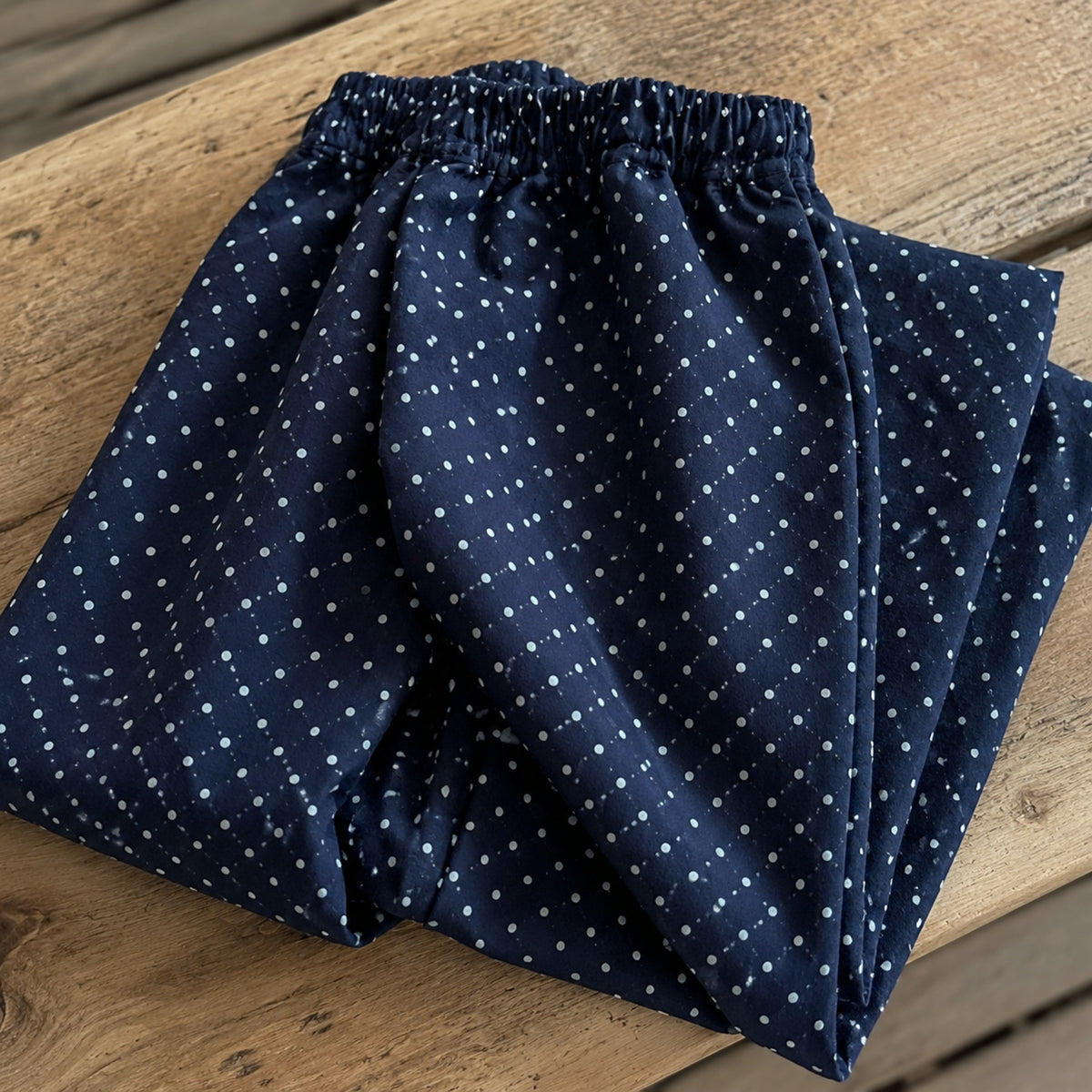 Close-up of elastic waist and tiny white dot print on navy wide-leg pants