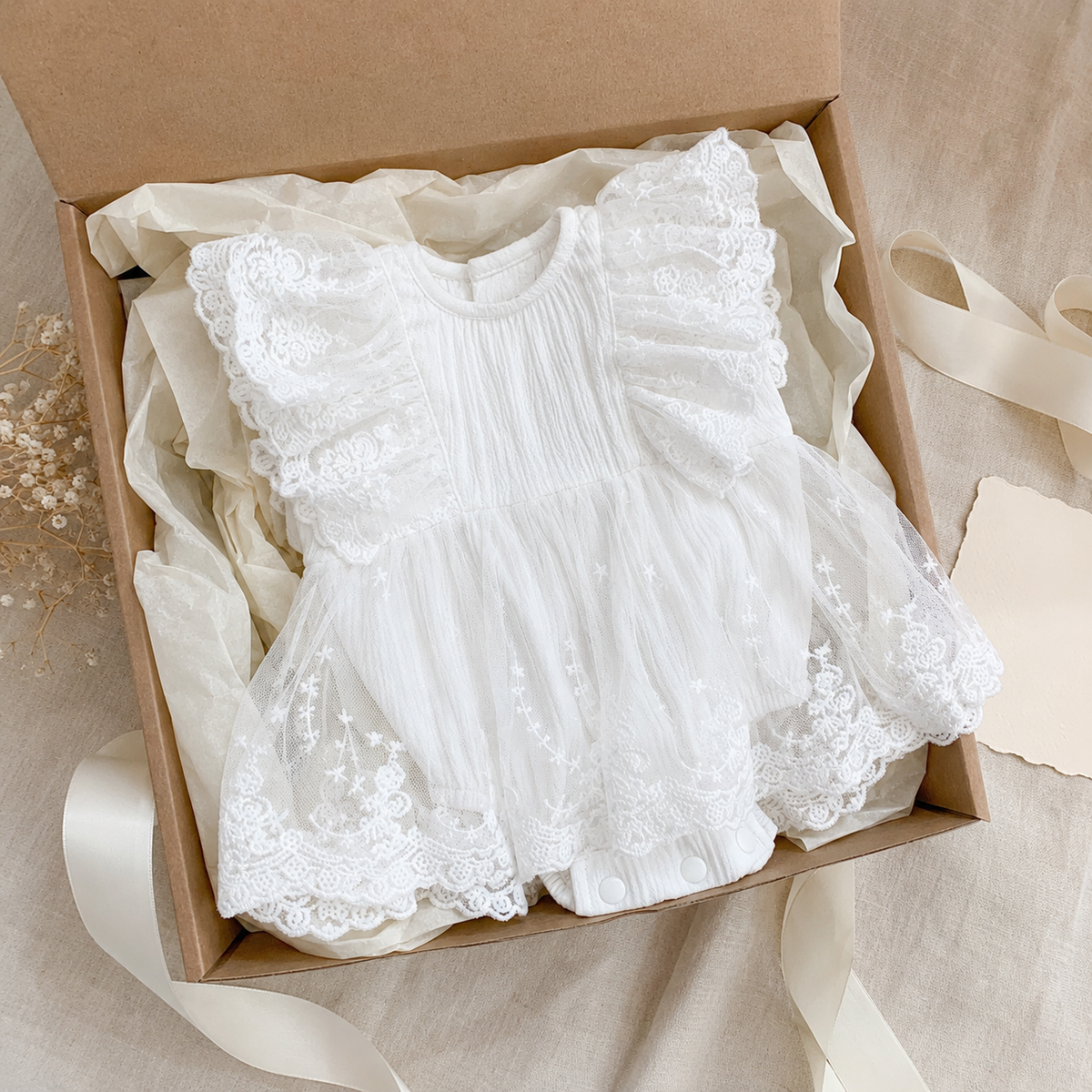 White lace baby romper dress presented as a gift