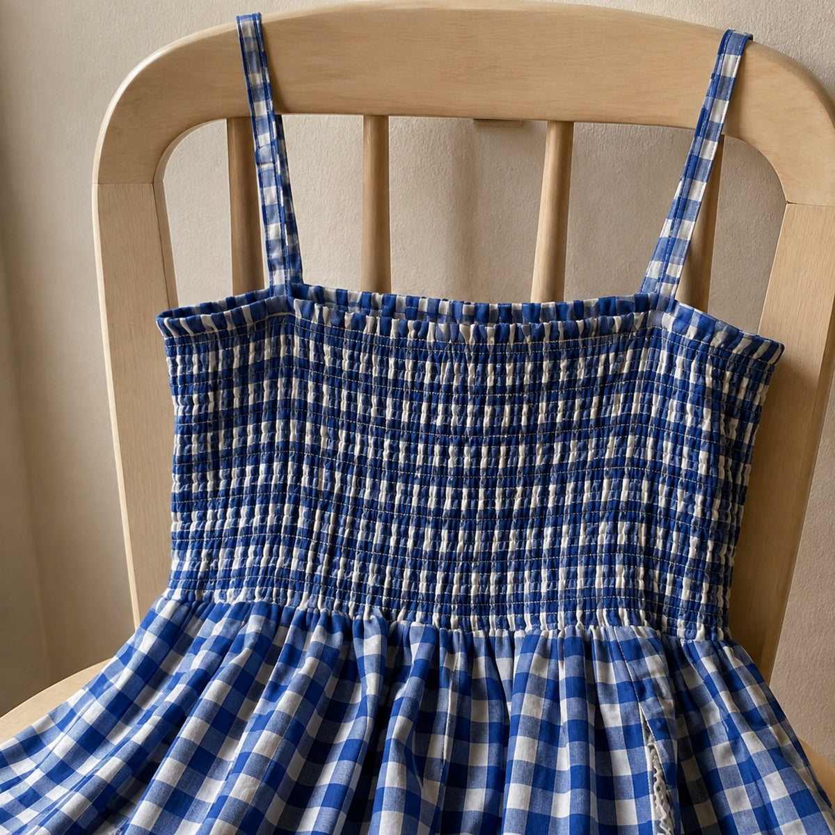 Close-up of the elastic smocked back and shoulder straps on the gingham dress