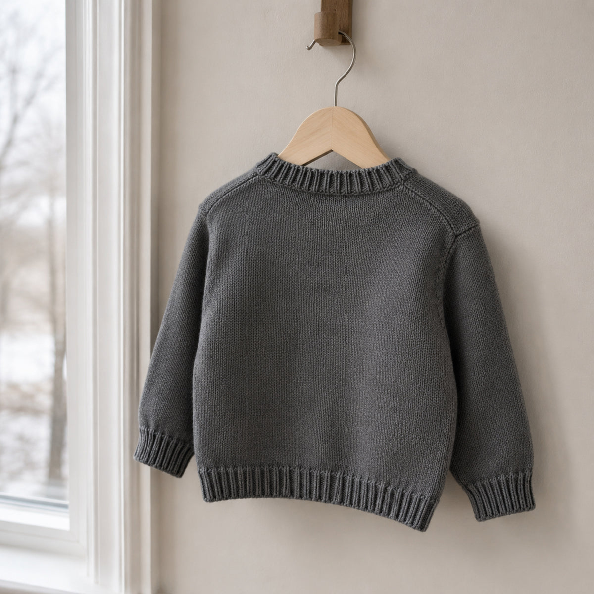 Plain back view of charcoal long-sleeve penguin knit cardigan