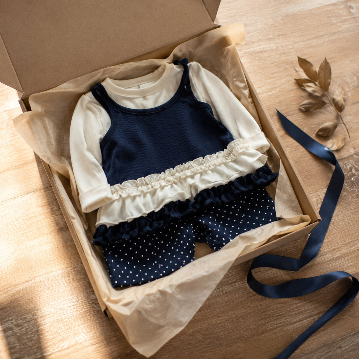 Complete navy and cream girls two-piece outfit folded in a Q4 gift box