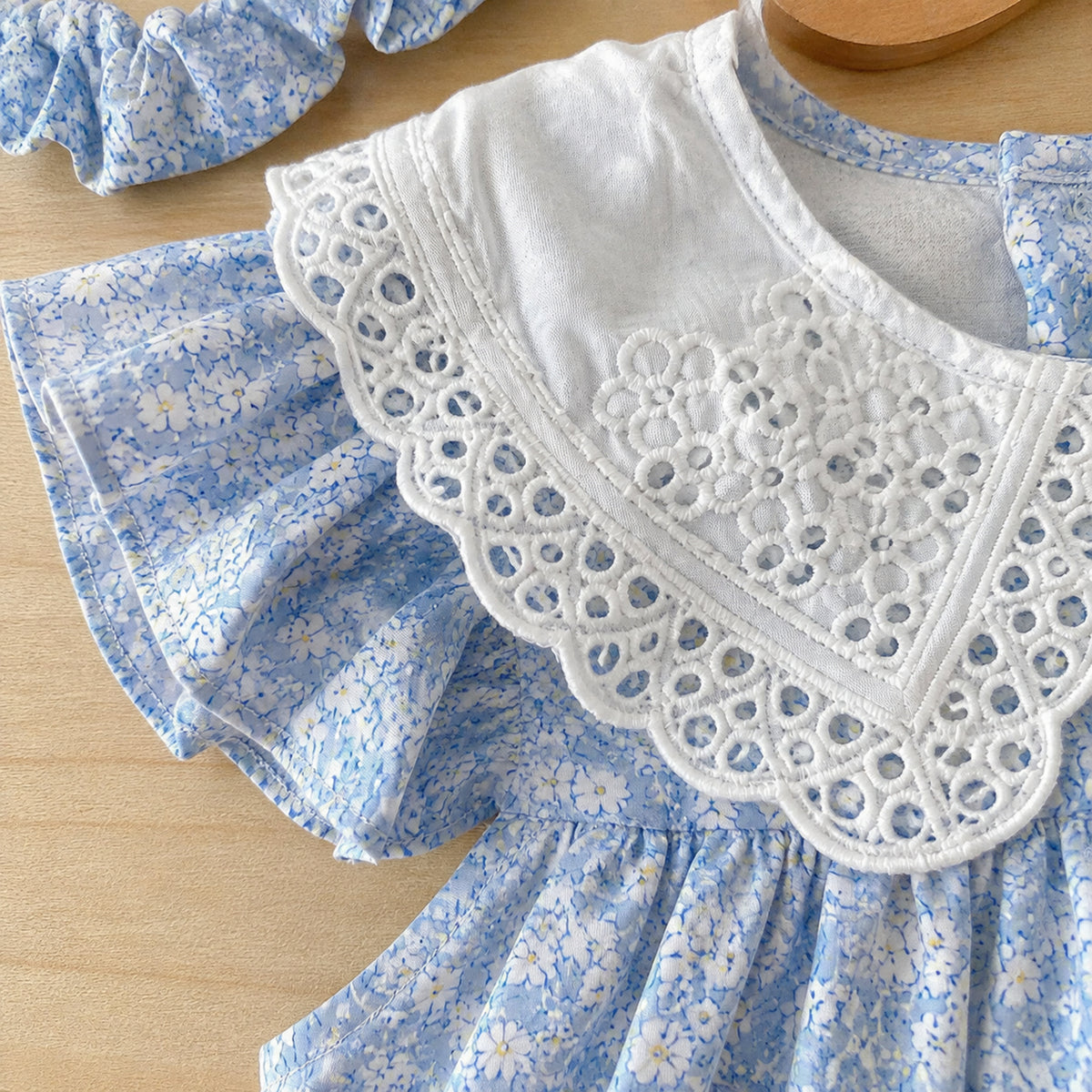 Close-up of wide white eyelet collar and blue floral cotton