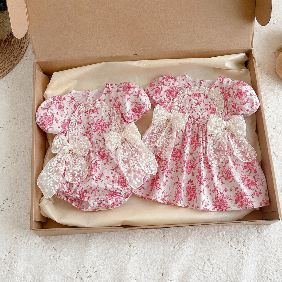Raspberry toile romper and dress folded separately in kraft gift box
