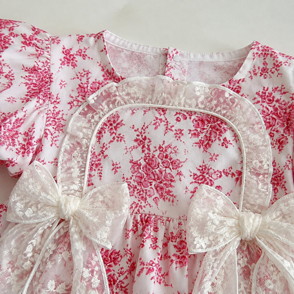 Close-up of toile print, square neckline and lace trim