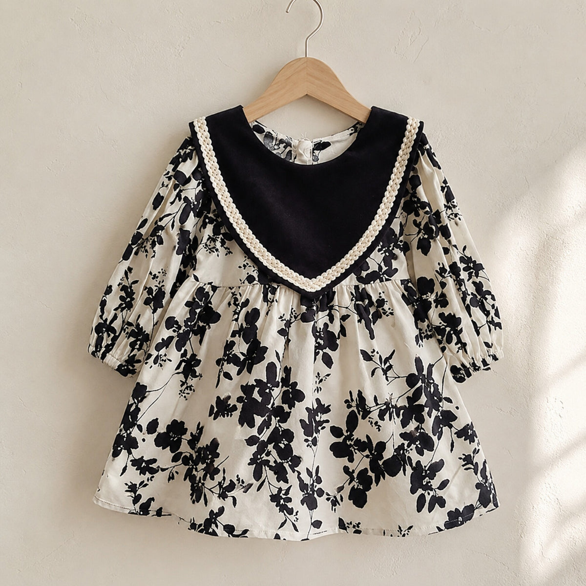 Black floral sailor collar girls dress on a wooden hanger