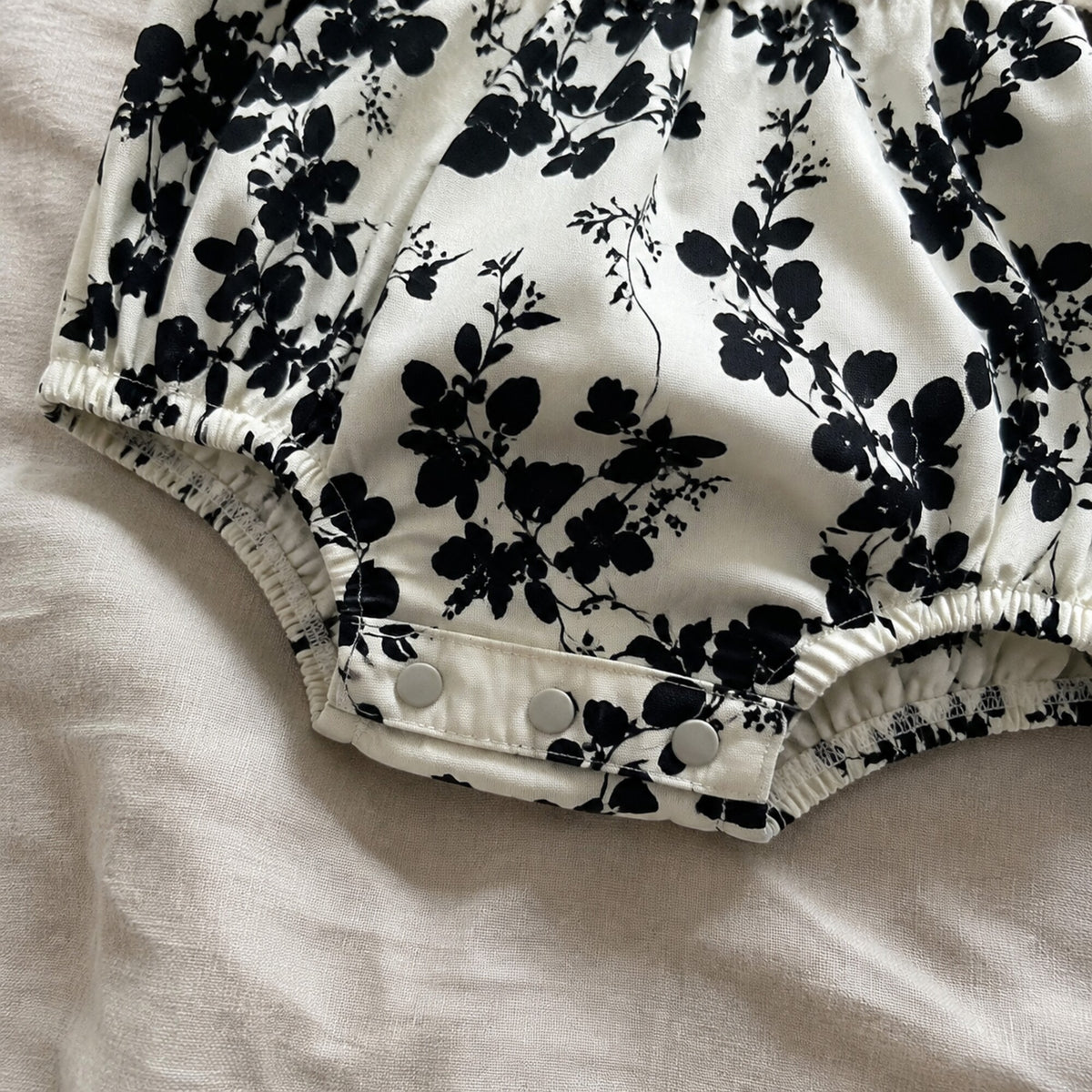 Close-up of the baby romper crotch snaps and elastic leg openings