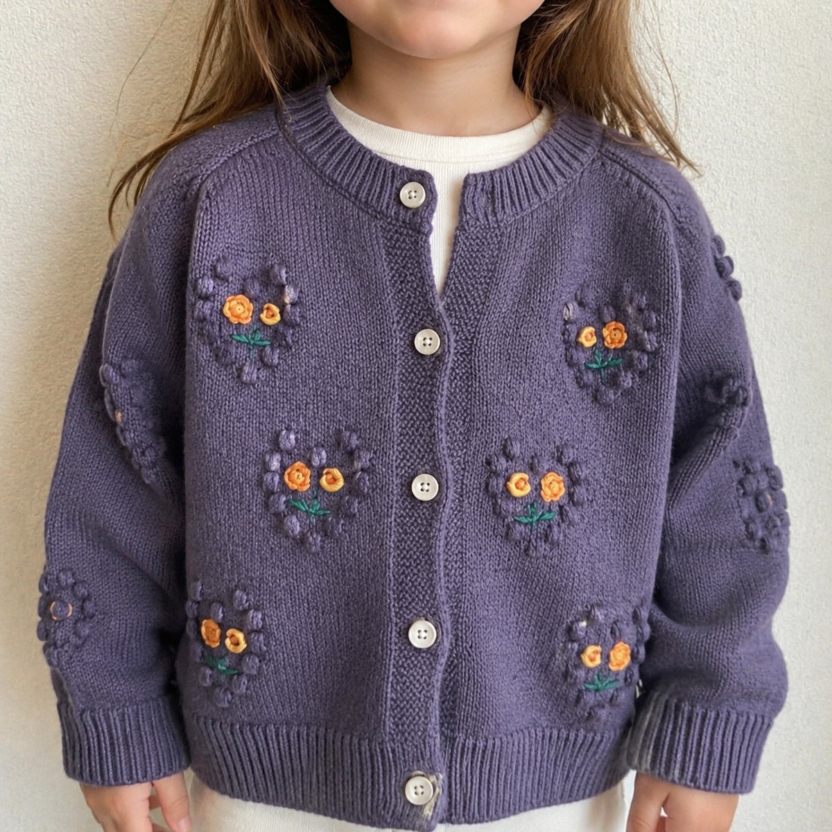 Front close-up of girls purple embroidered floral knit cardigan