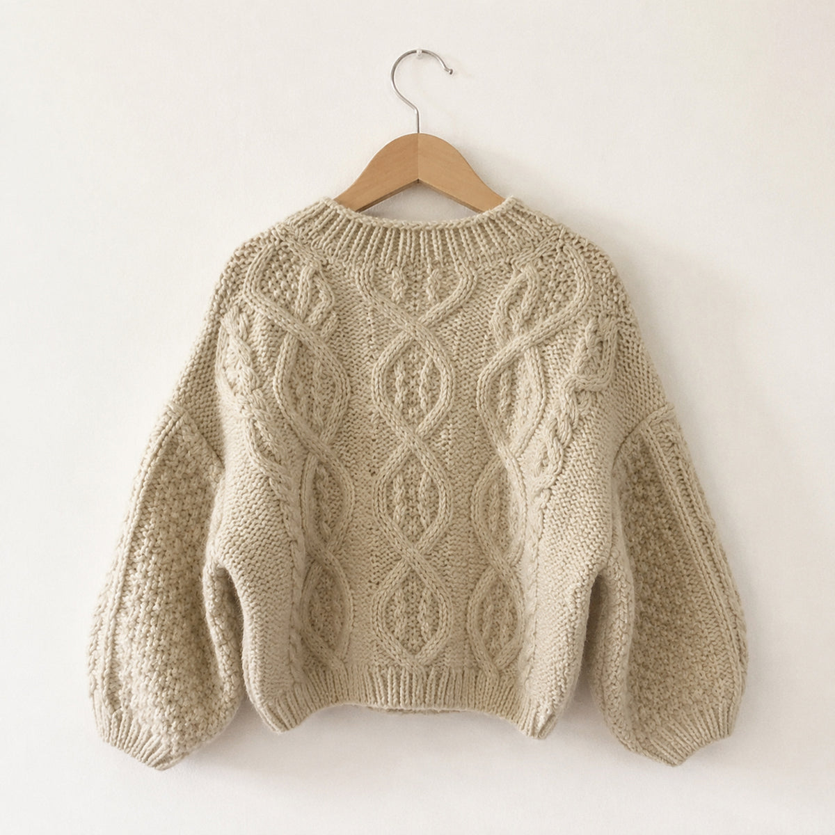 Cream cable-knit cardigan back view
