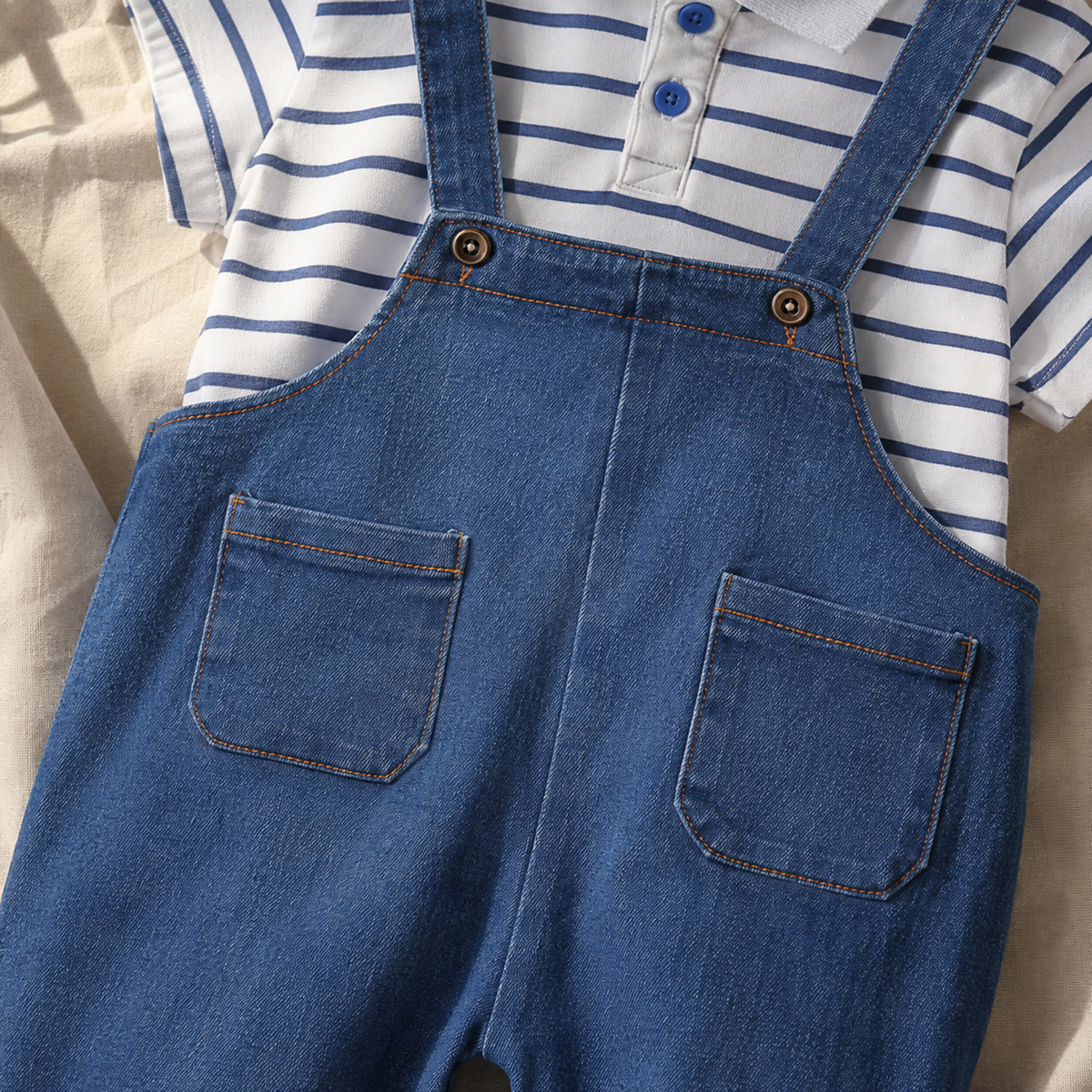 Close-up of denim bib pockets, buttons, and contrast stitching