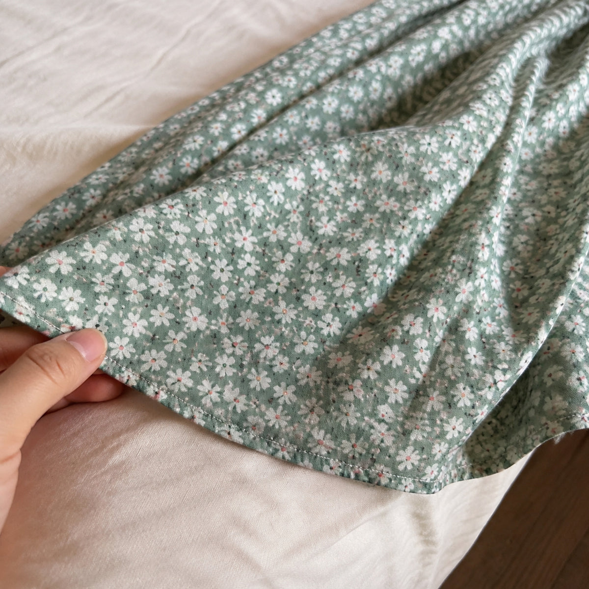 Close-up of the floral dress hem, stitching and lightweight fabric