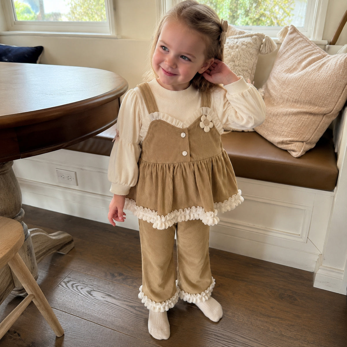 Girl wearing warm khaki ruffle pinafore, top and pants set