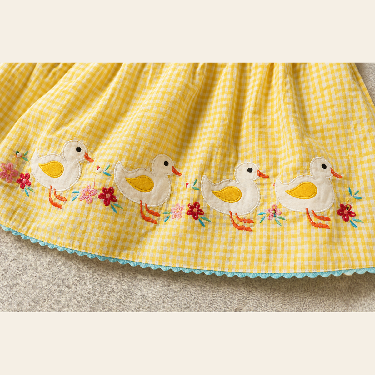 Four duck appliqués and floral embroidery close-up