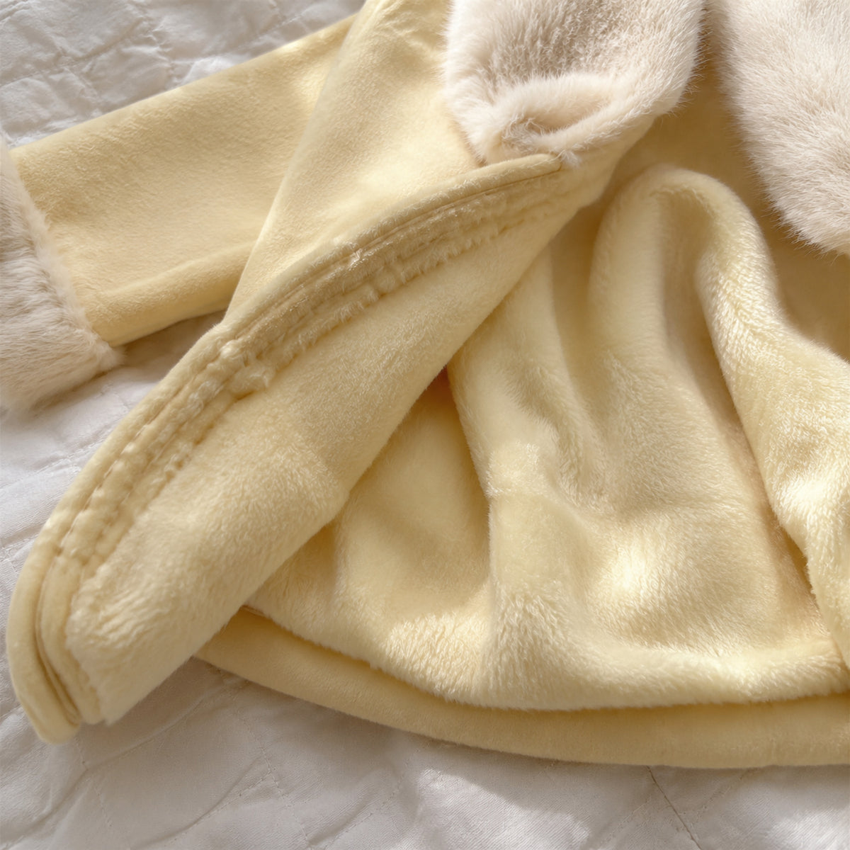 Close-up of the warm fleece-lined interior of the pale yellow jacket