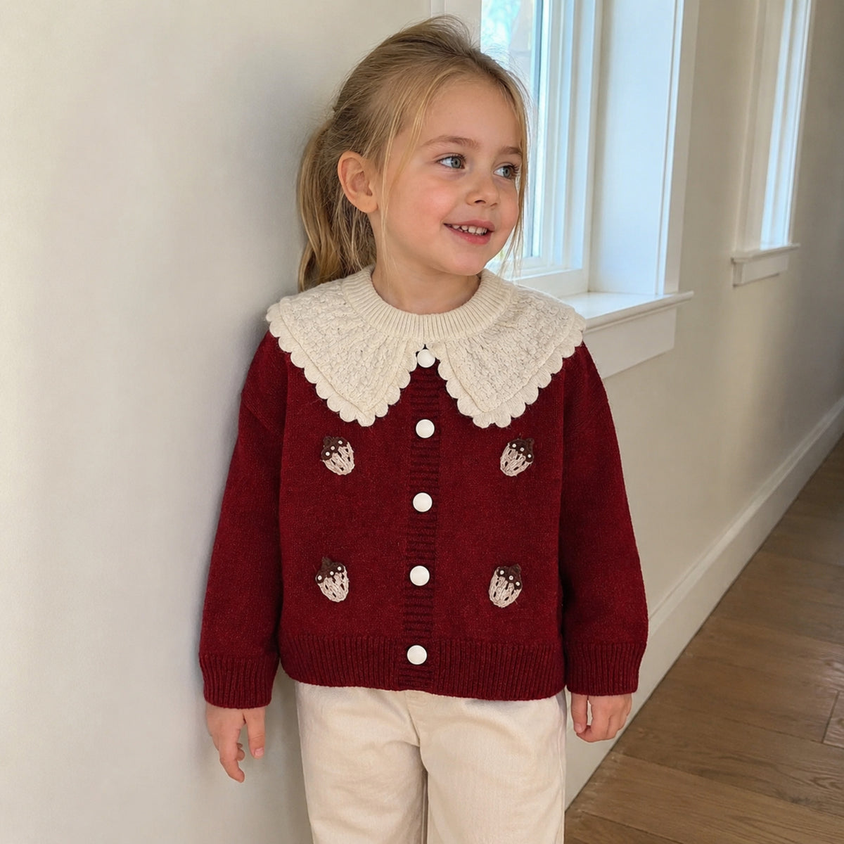 Girls burgundy strawberry knit cardigan styled without the plaid skirt