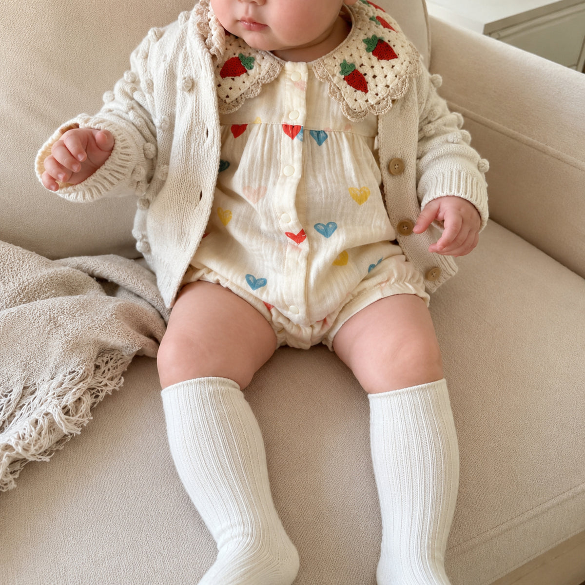 Baby wearing heart romper with oatmeal cardigan for fall