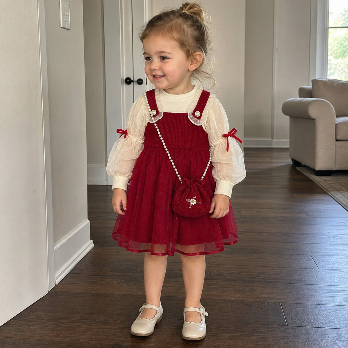 Toddler girl wearing red pinafore dress set with mini purse at home