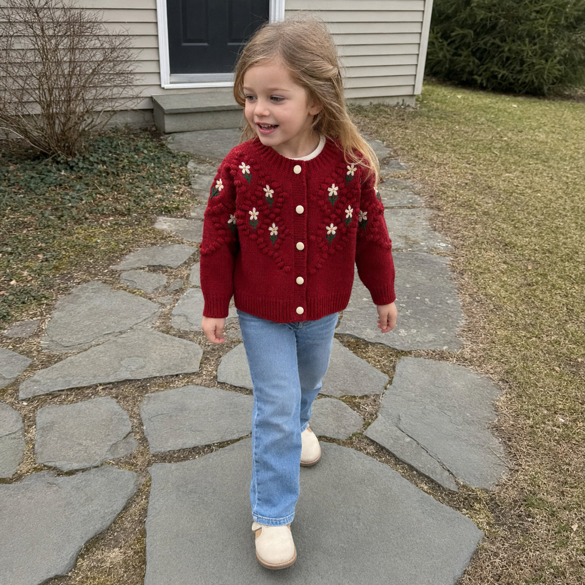 Girl wearing red floral cardigan outdoors