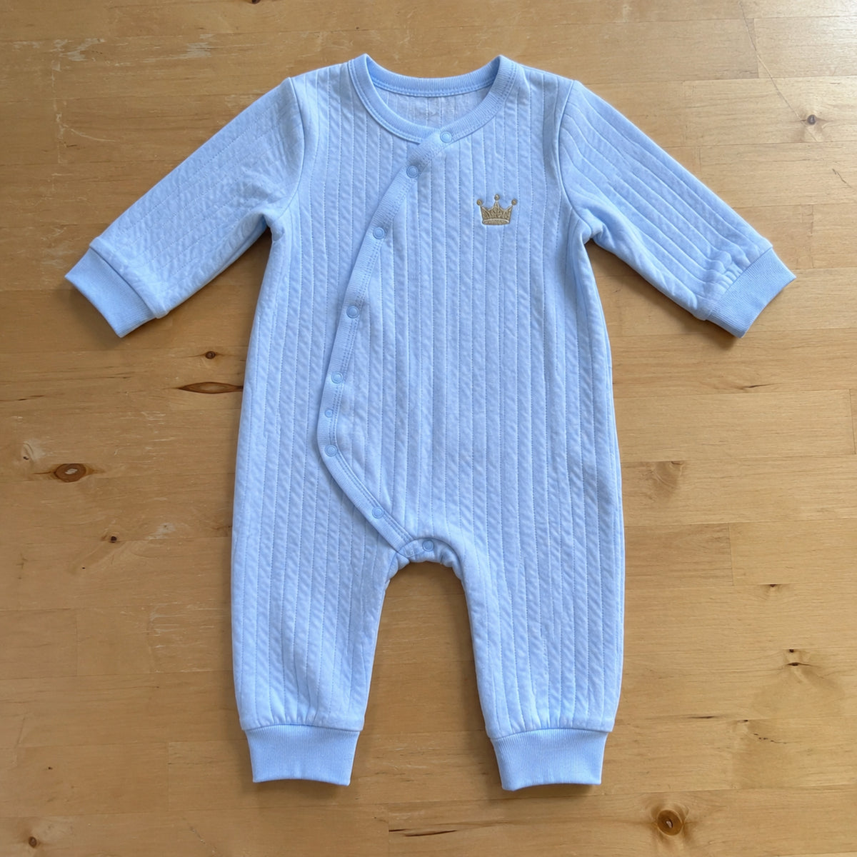 Blue quilted cotton crown romper flat lay