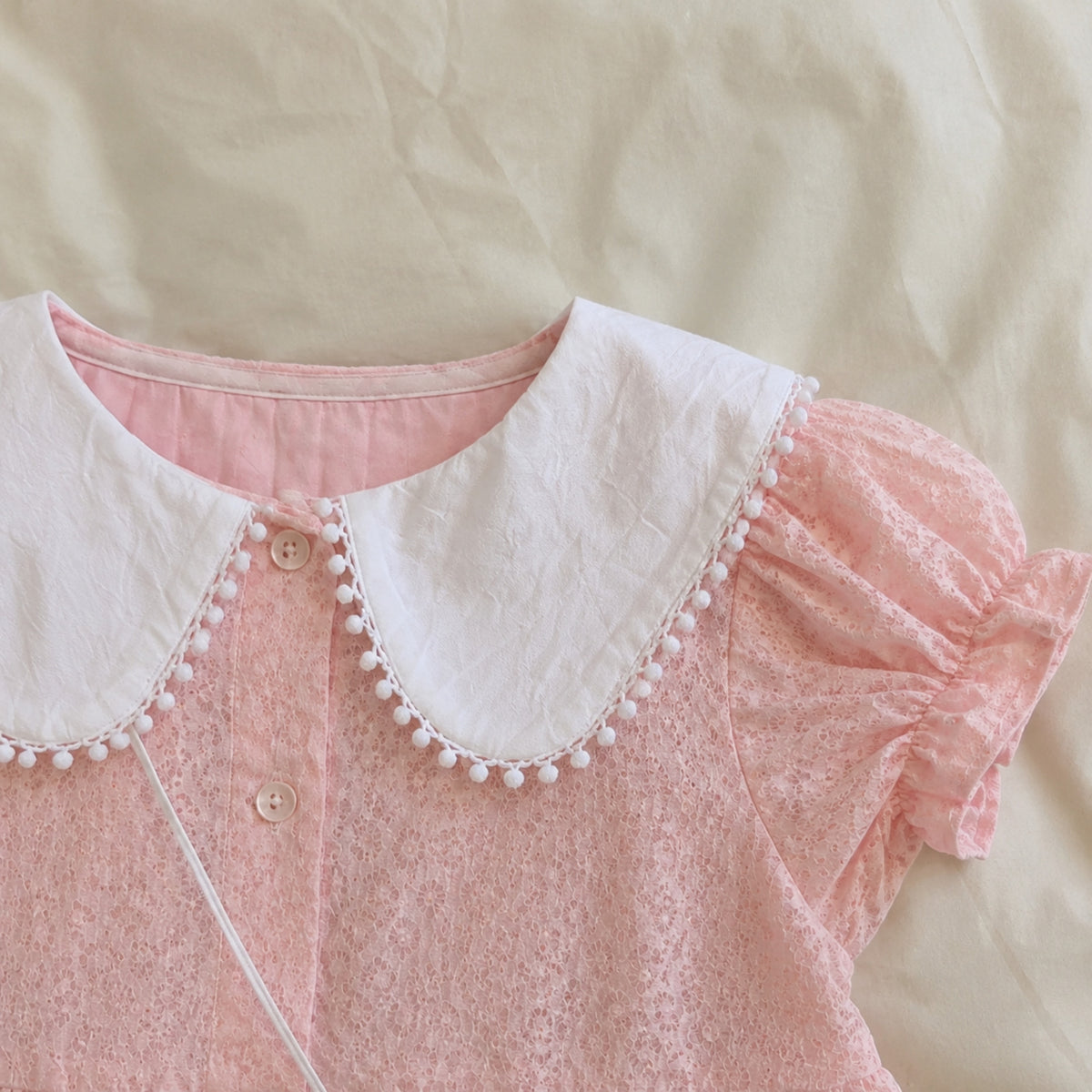 White pom trim Peter Pan collar and puff sleeve detail