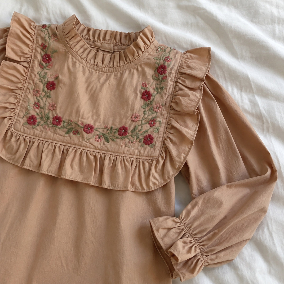 Floral embroidery and layered ruffle bib detail