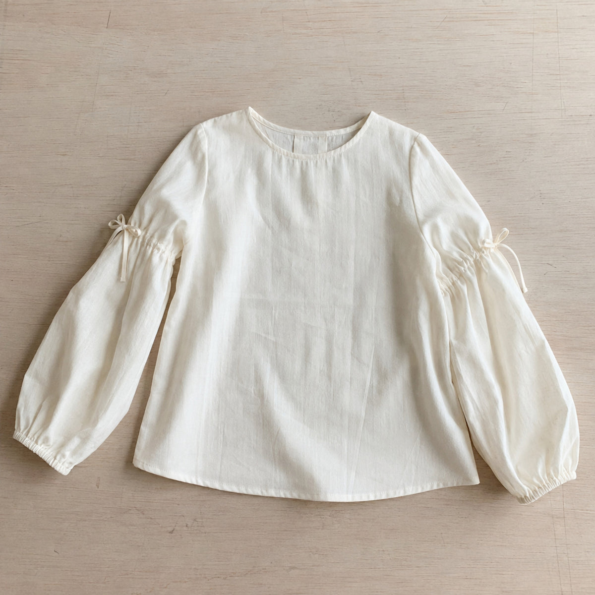 Ivory balloon sleeve blouse bow and cuff detail