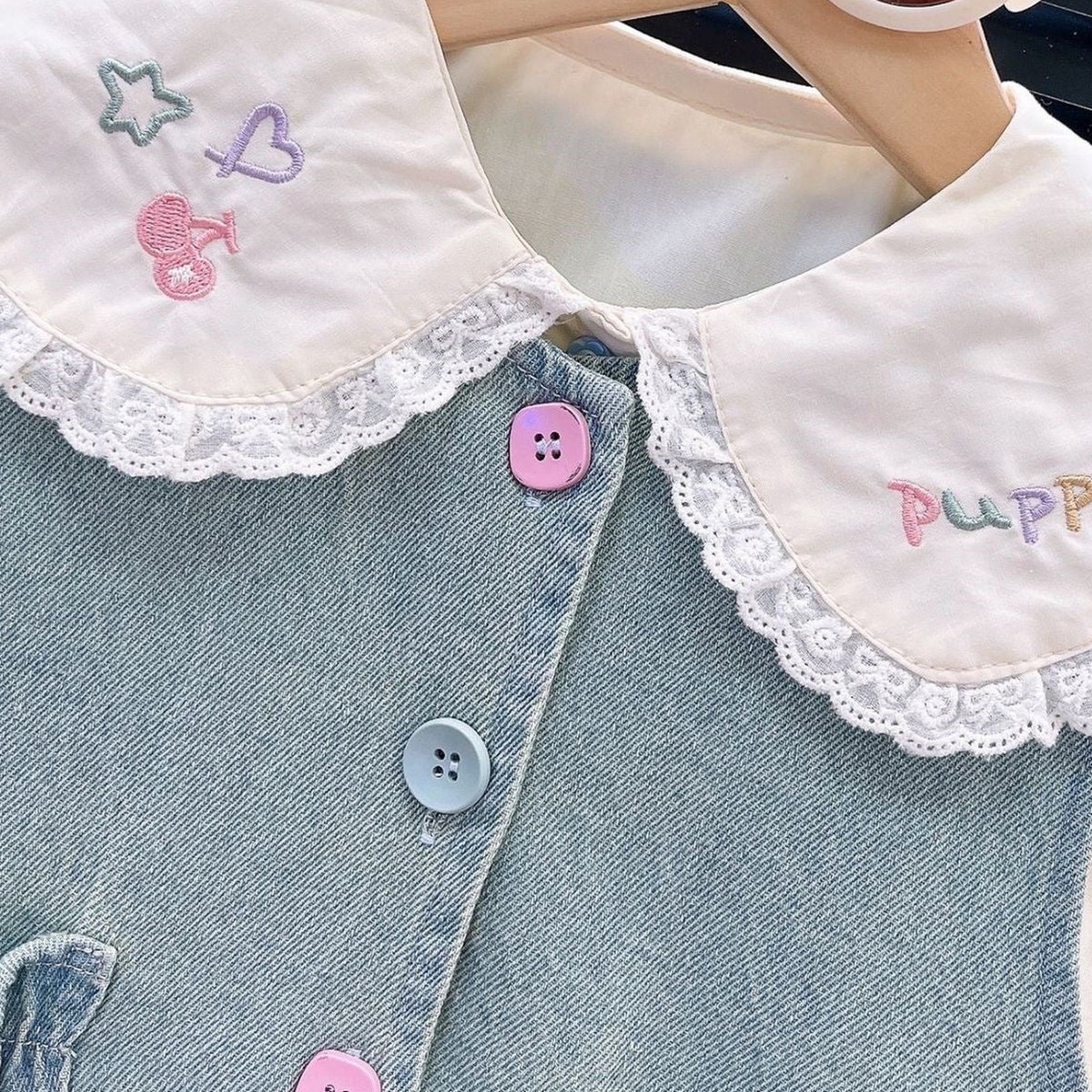 Real close detail of lace collar embroidery and denim texture