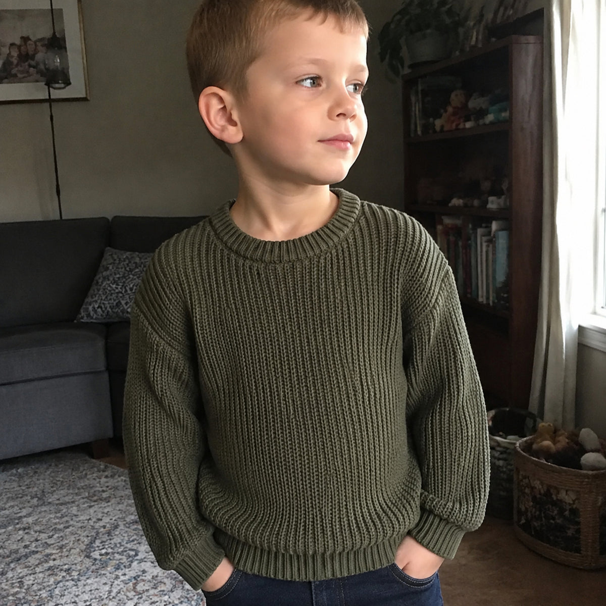 Boy wearing army green chunky cotton knit pullover at home