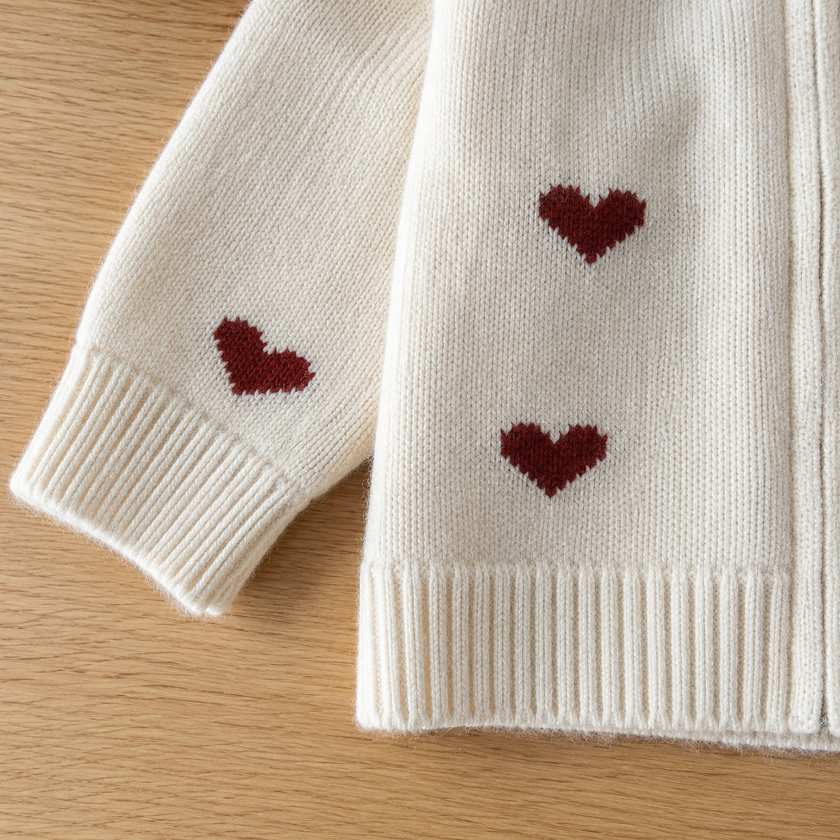 Close-up of off-white knit red hearts ribbed cuff and hem