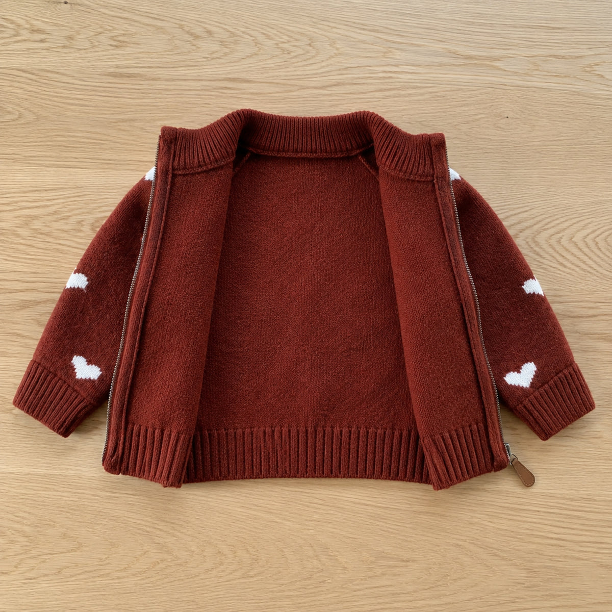 Open red heart cardigan showing plain unlined knit interior and zipper