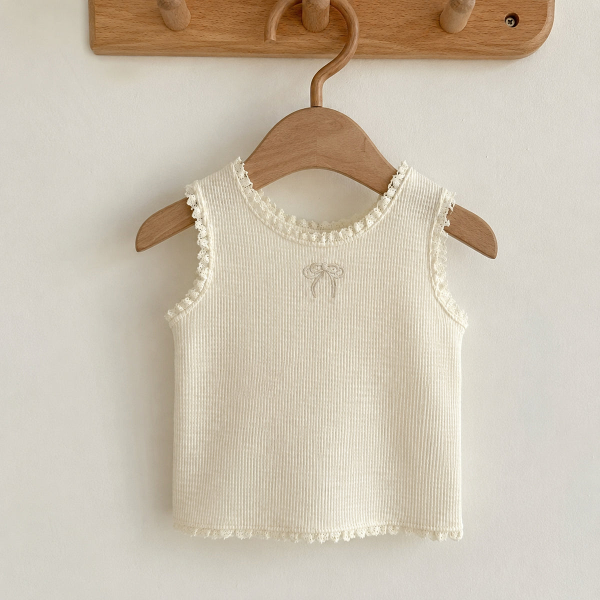 Ivory open-knit sleeveless girls vest shown separately